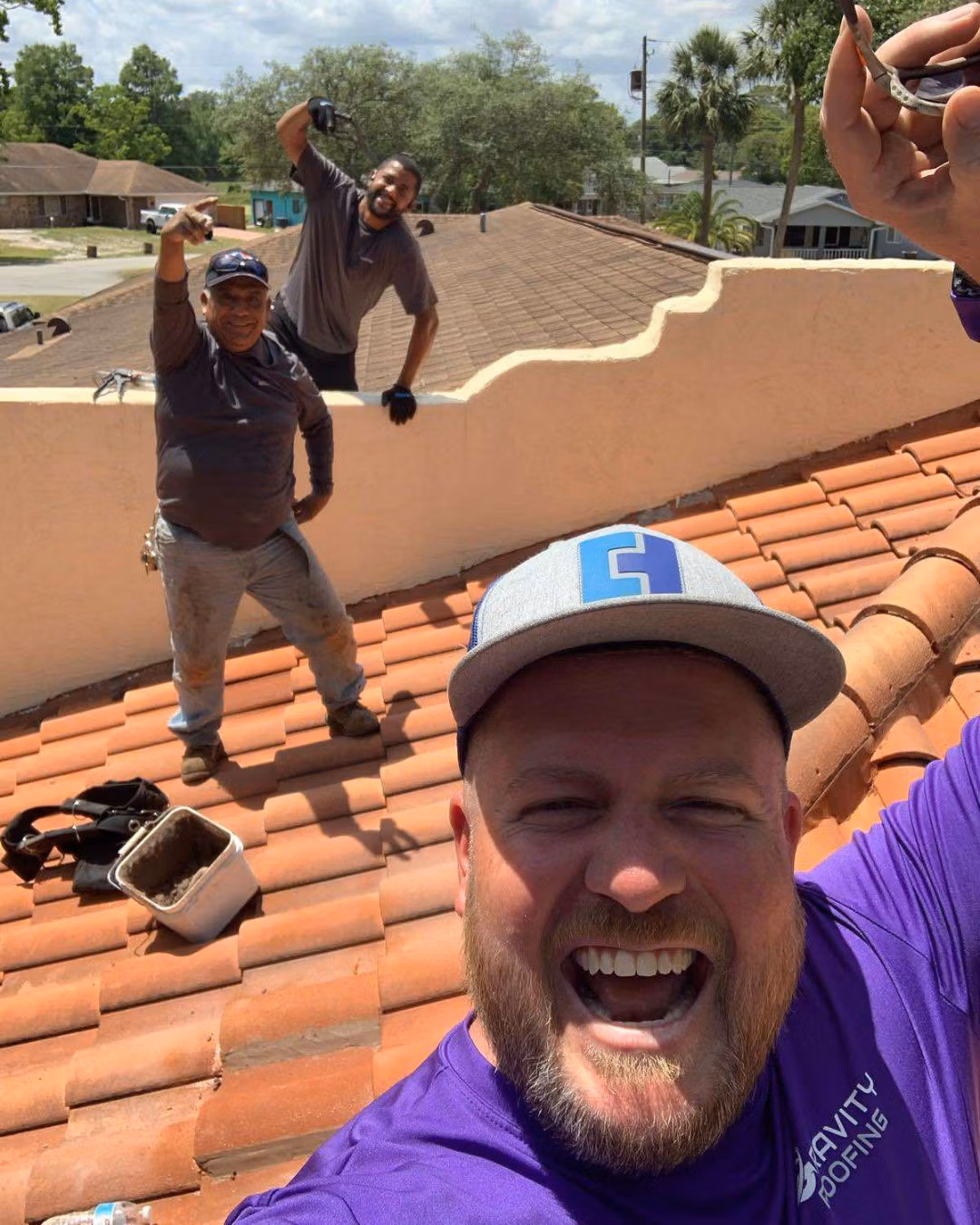 Gravity Roofing residential roof repair crew smiling and working on a tile roof in Central Florida