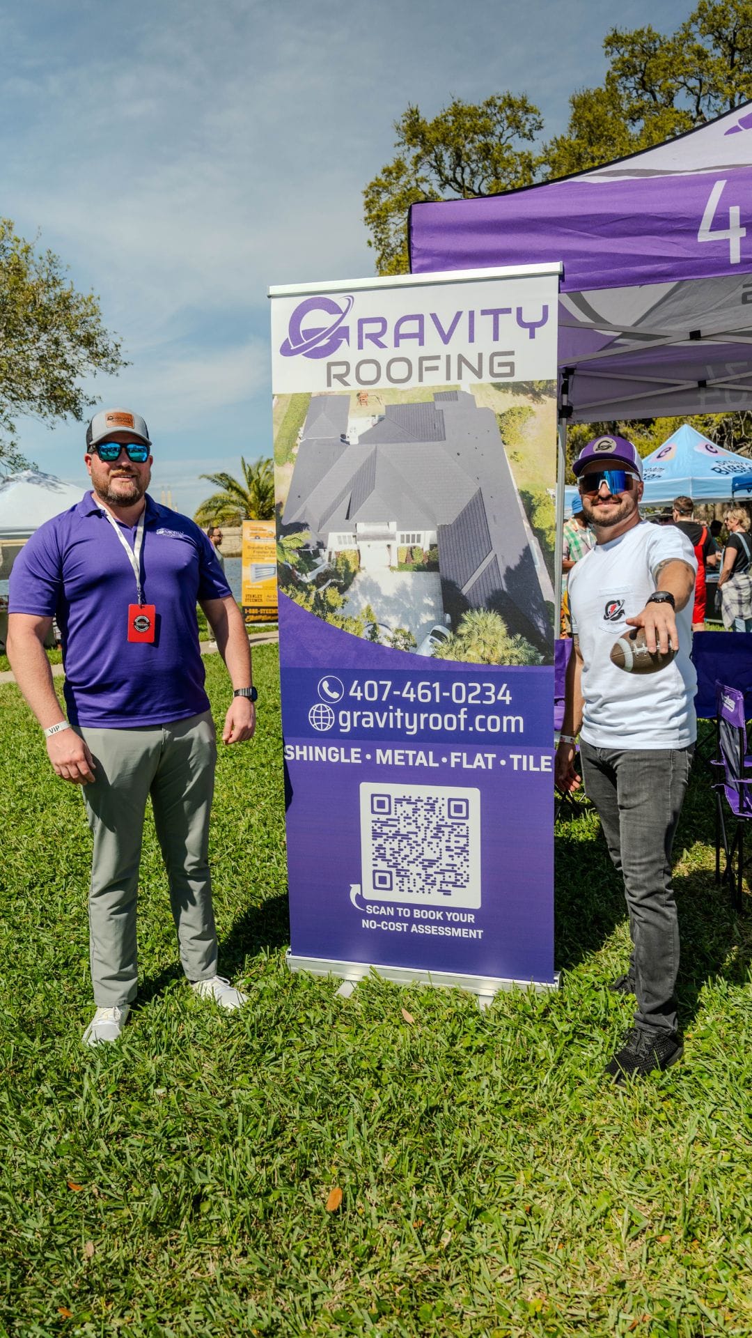 Gravity Roofing team at Brunch in the Park 2025 in Orlando, FL, standing next to branded event banner and QR code