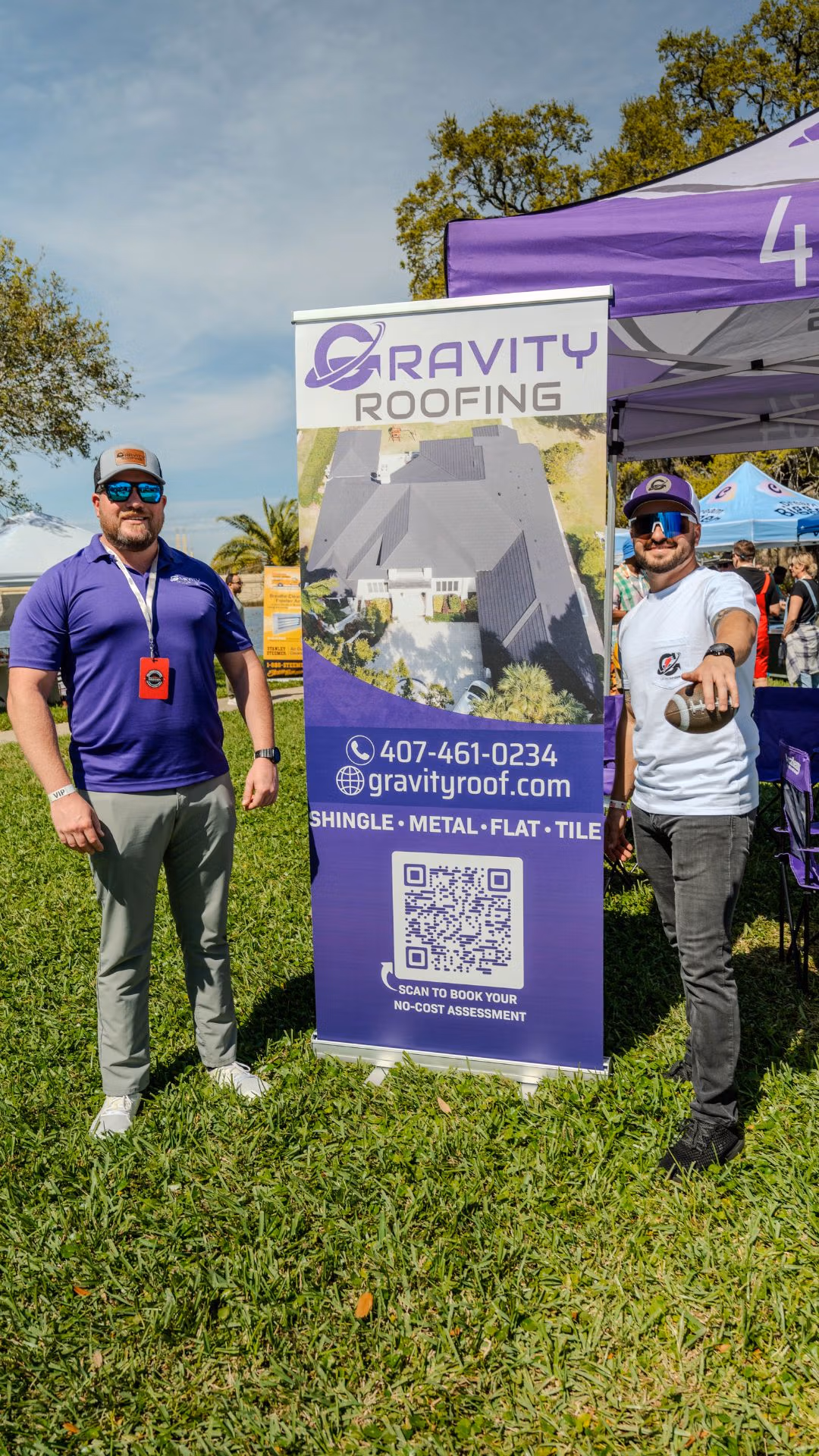 Gravity Roofing team at Brunch in the Park 2025 in Orlando, FL, standing next to branded event banner and QR code