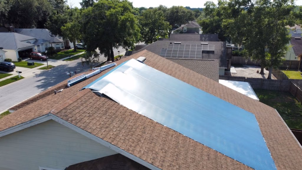 Emergency roofing tarp protecting a storm-damaged roof in Central Florida neighborhood