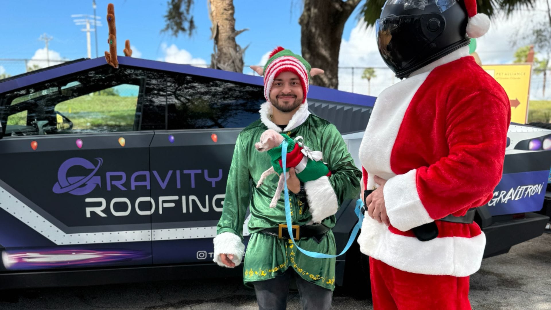 Gravity Roofing's Space Santa and an elf pose in front of the Gravitron during their holiday visit to the Pet Alliance of Greater Orlando in Sanford, FL