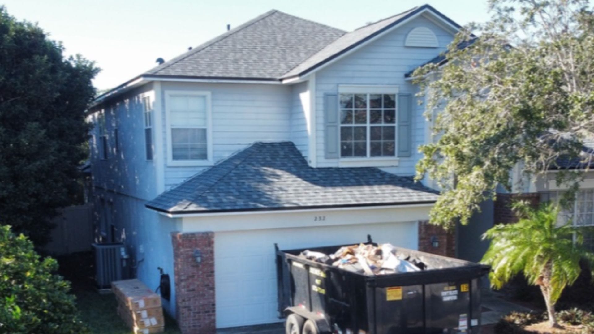 Roof inspection Casselberry — roofing expert inspecting shingles on a Florida home after storm season.