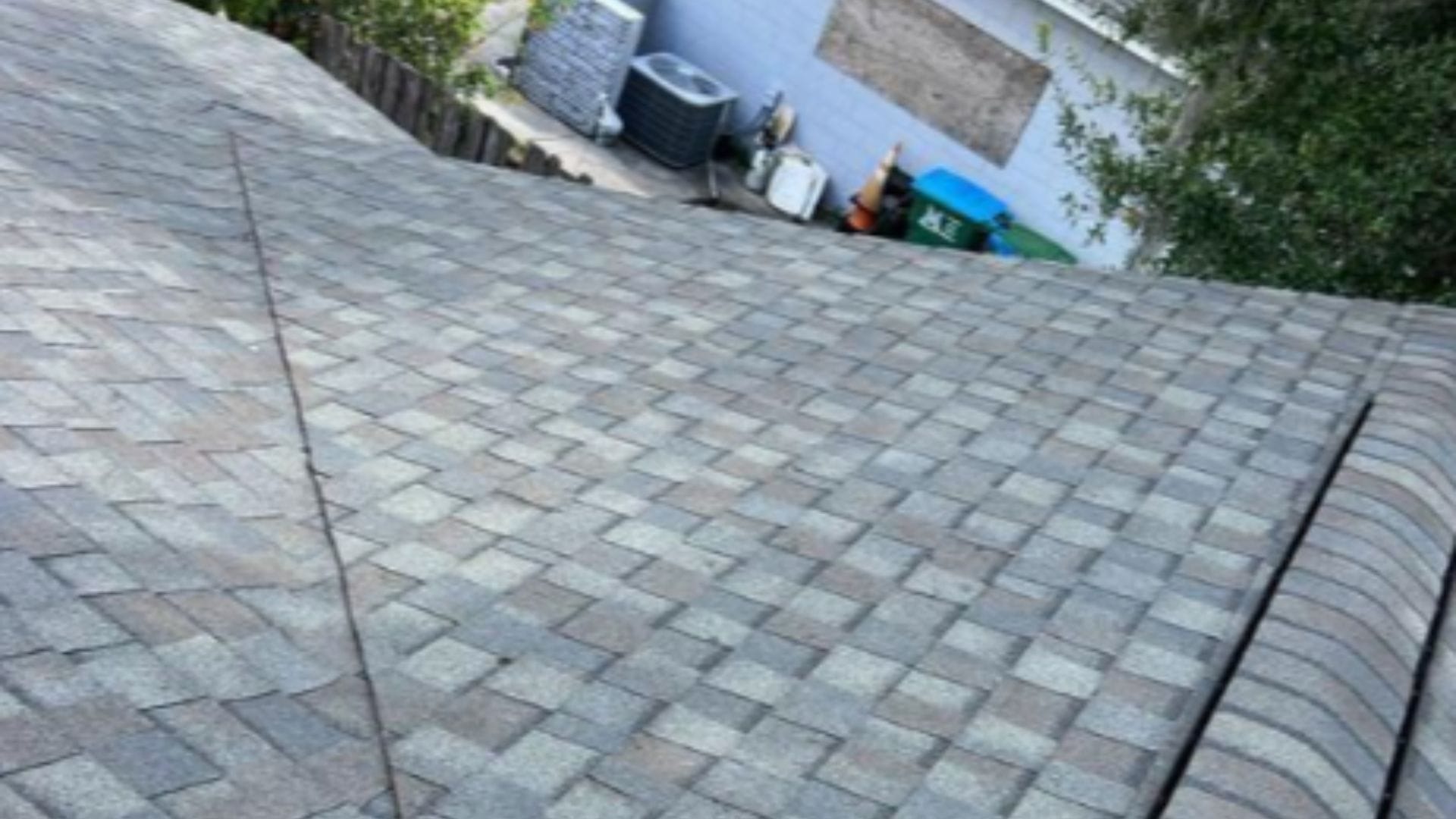 Roof inspection Maitland — roofing expert inspecting shingles on a Florida home after storm season.