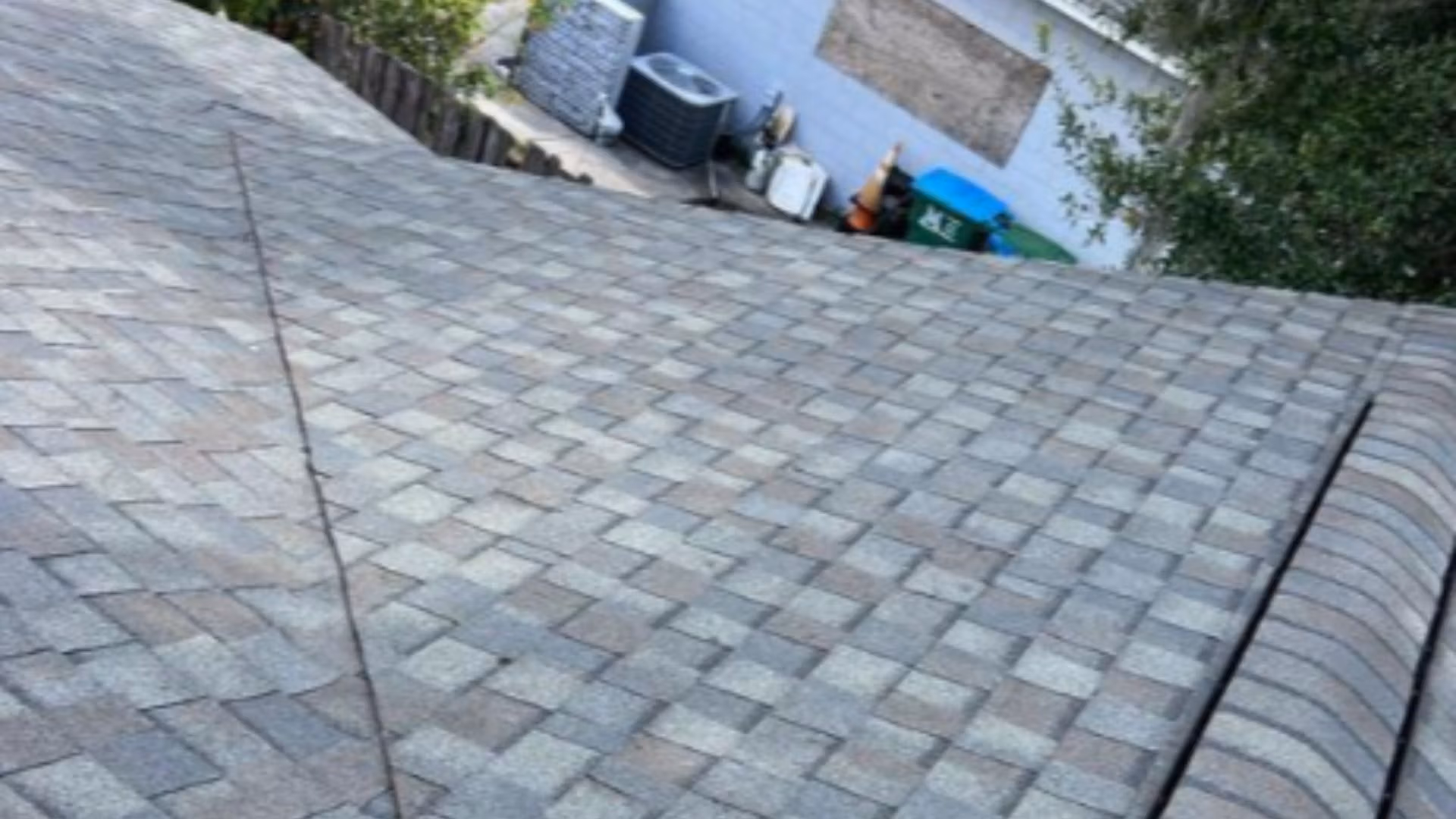 Roof inspection Maitland — roofing expert inspecting shingles on a Florida home after storm season.
