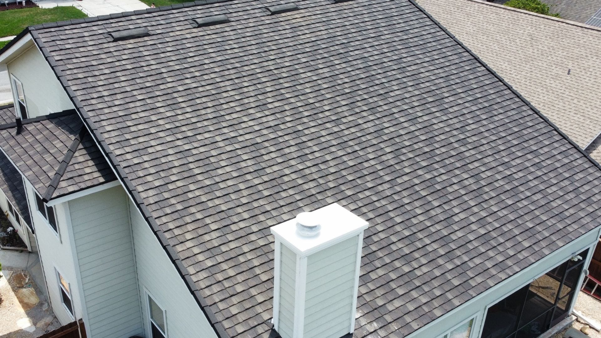 Roof inspection Sanford — roofing expert inspecting shingles on a Florida home after storm season.