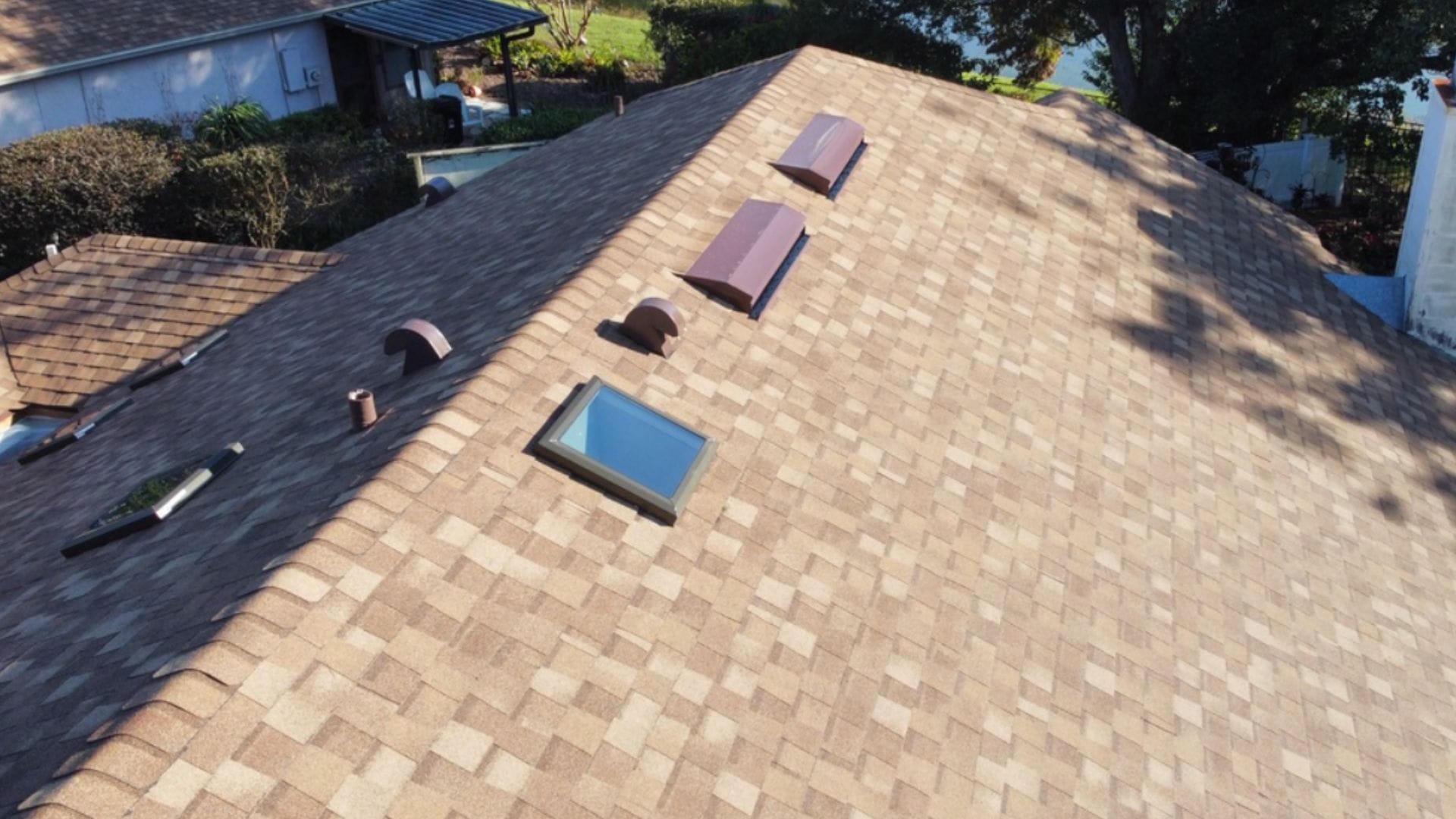 Roof inspection Orlando — roofing expert inspecting shingles on a Florida home after storm season.