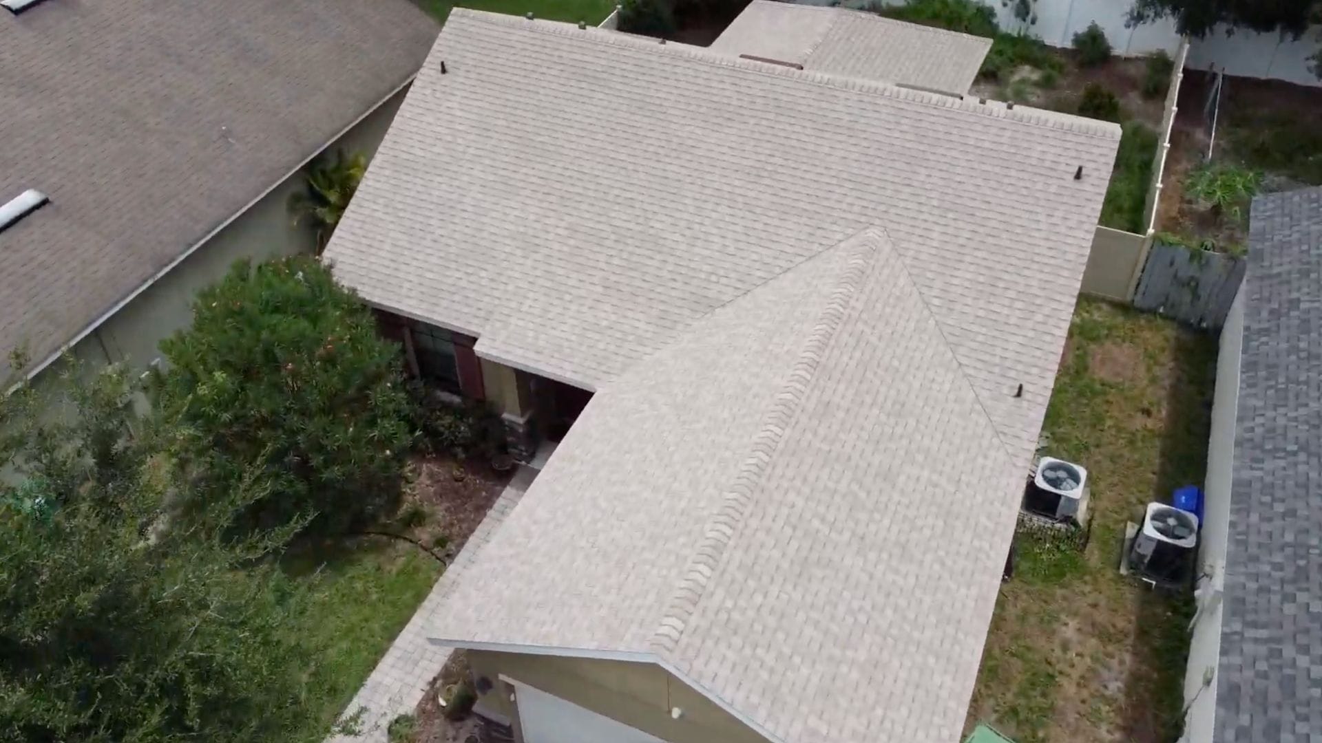 Roof inspection Deland — roofing expert inspecting shingles on a Florida home after storm season.