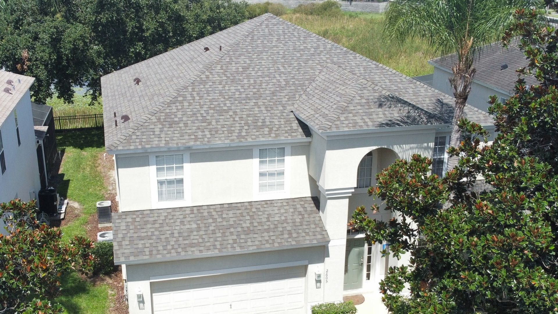 Roof inspection Kissimmee — roofing expert inspecting shingles on a Florida home after storm season.