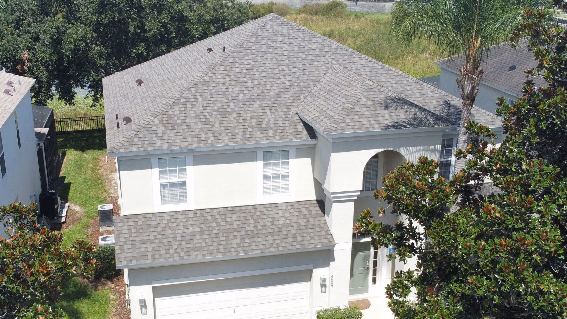 Roof inspection Kissimmee — roofing expert inspecting shingles on a Florida home after storm season.