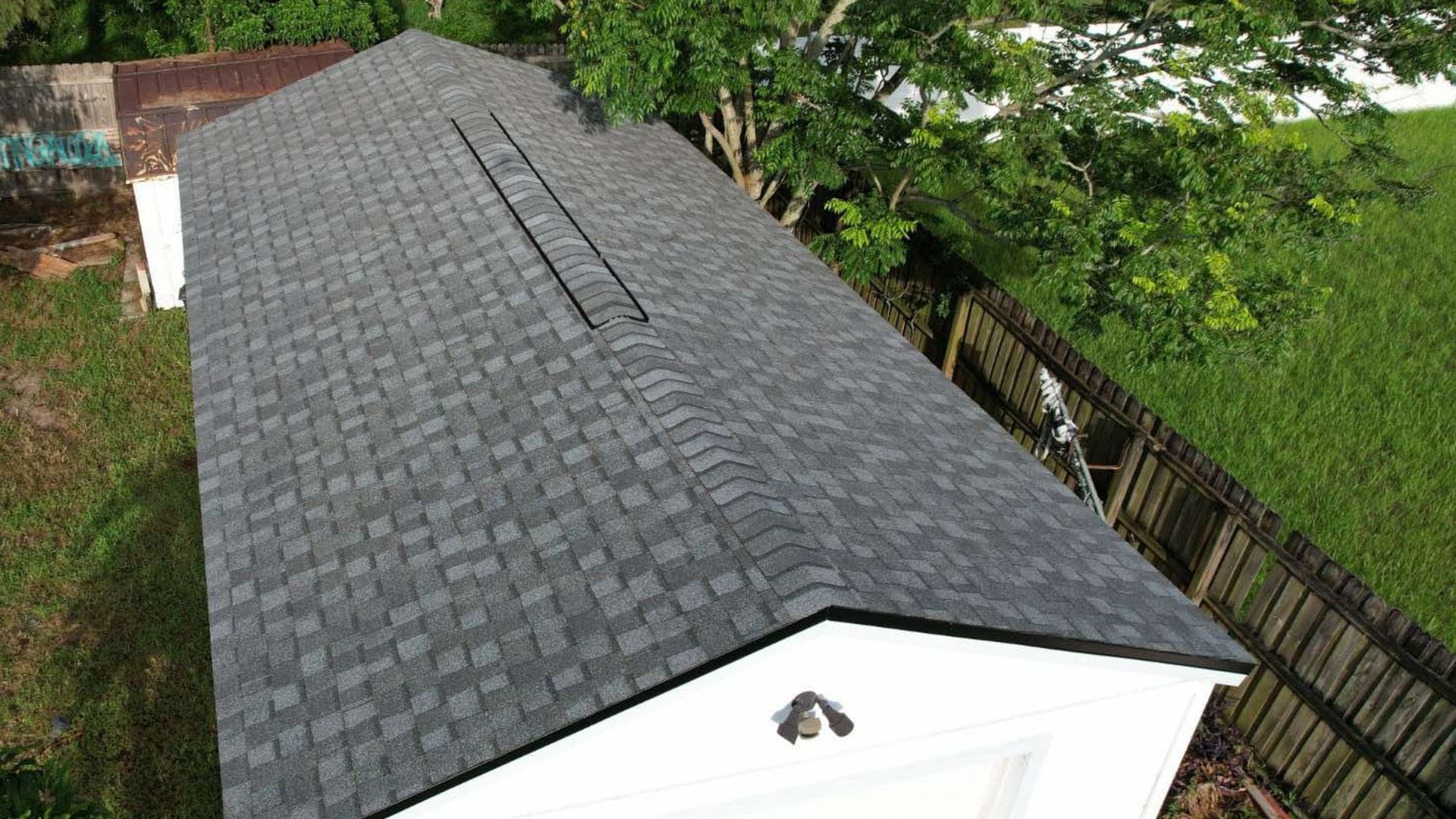Roof inspection Longwood — roofing expert inspecting shingles on a Florida home after storm season.
