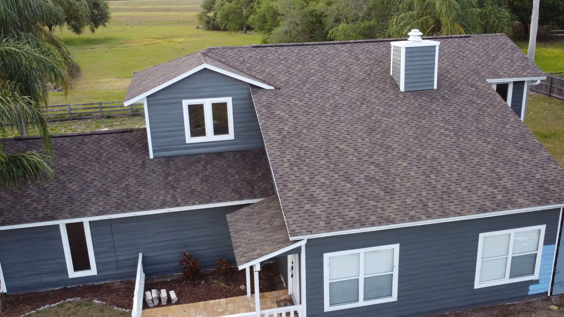 Roof inspection Saint Cloud — roofing expert inspecting shingles on a Florida home after storm season.